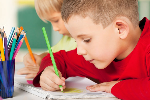 Children sitting at desk writing.