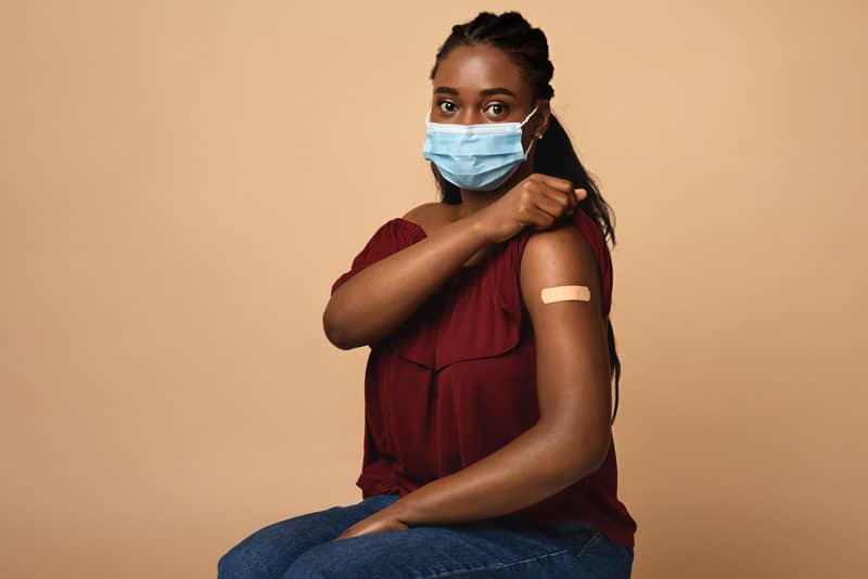 african american woman with face mask after immunization