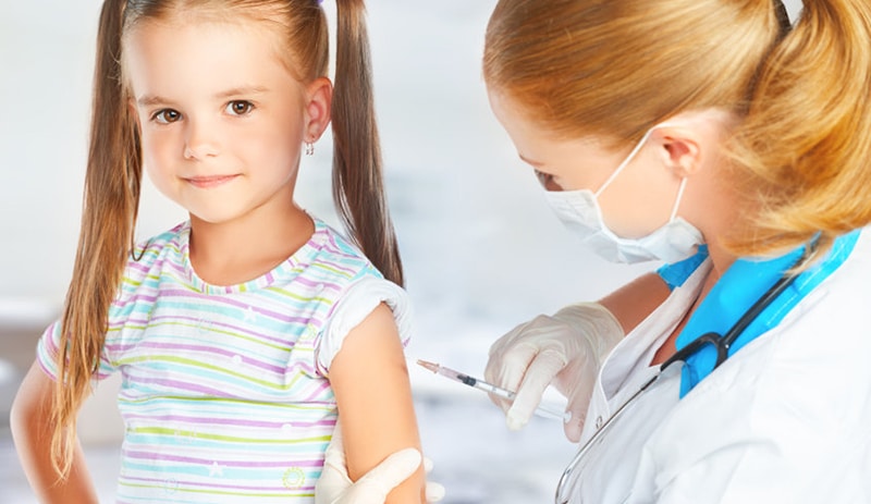 Illinois Department of Public Health Adopts CDC Recommendations for Pfizer-BioNTech COVID-19 Vaccine for Children Ages 5 through 11 a woman physician gives a young girl a vaccination