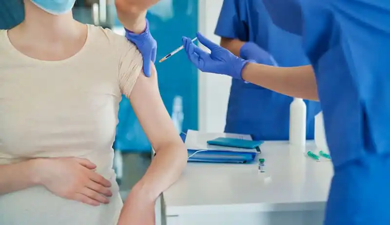 close-up of pregnant woman getting vaccinated