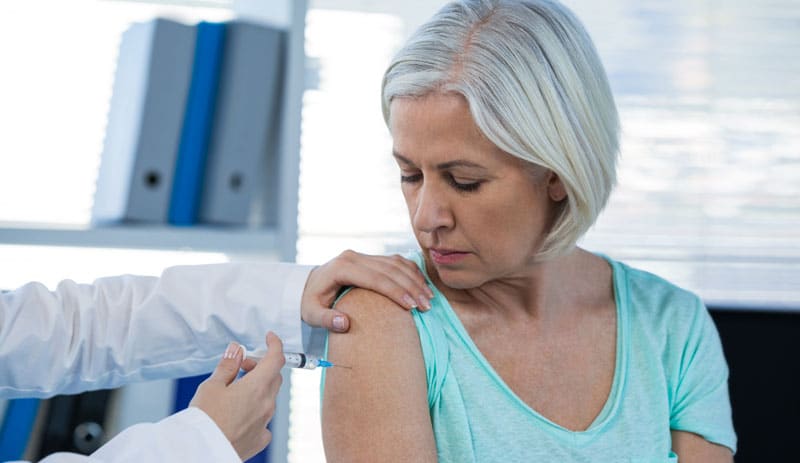 doctor giving injection to woman over 60 doctor giving injection to woman over 60