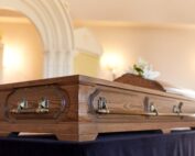 Wood casket sitting on table in funeral home