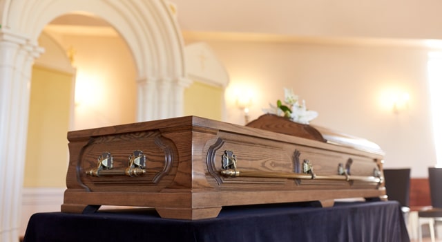Wood casket sitting on table in funeral home