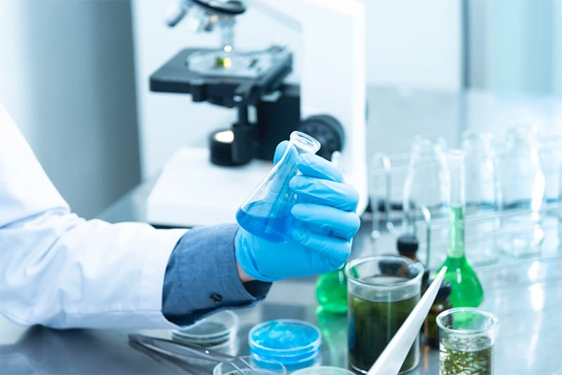 person holding flask in lab