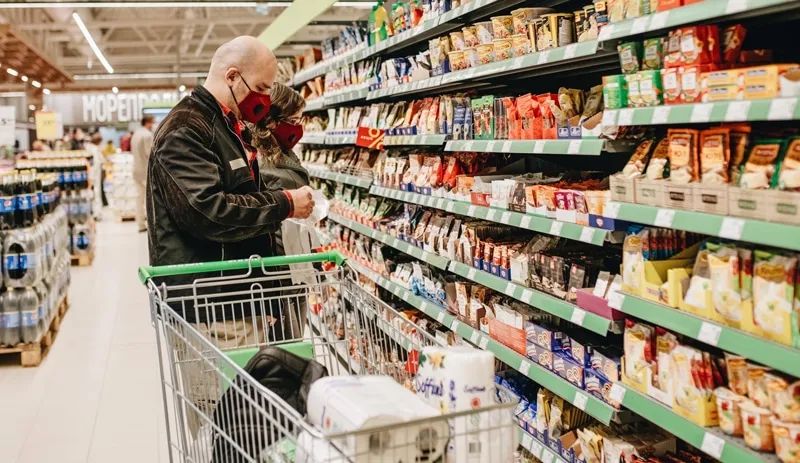 couple shopping in a grocery store wearing face masks