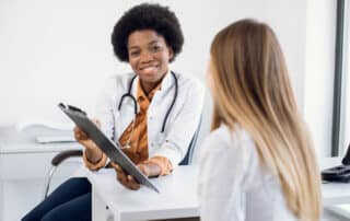 smiling african american female doctor talking to patient
