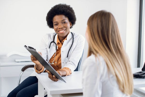 smiling african american female doctor talking to patient