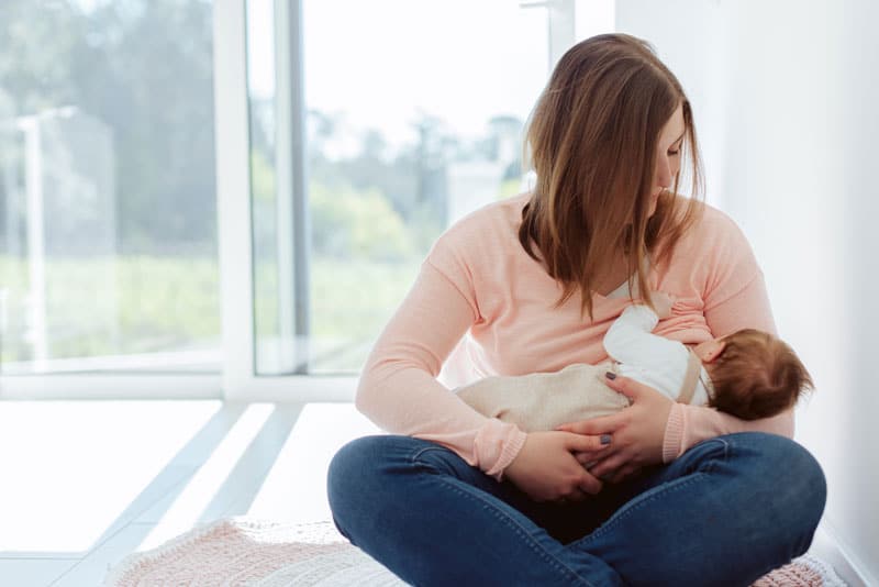 young mother breastfeeding newborn baby